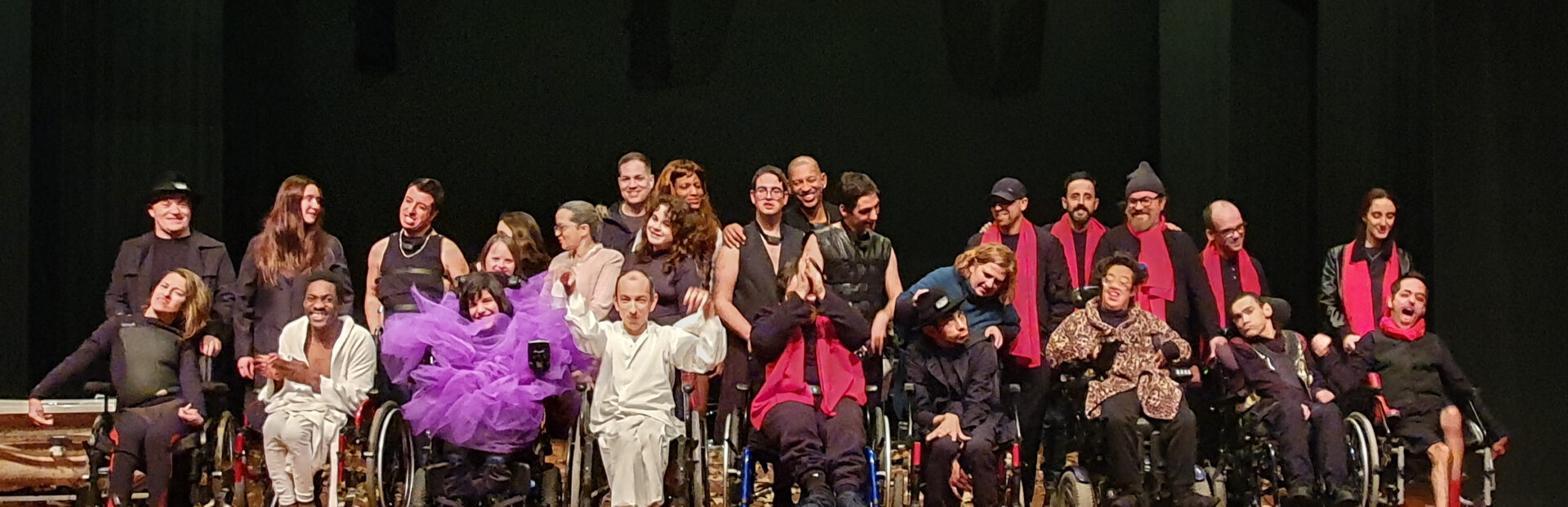 Perto de três dezenas de pessoas, em palco, alinhadas para a fotografia. Essencialmente são atores e atrizes da Companhia Era uma vez Teatro da APPC. Aparecem, igualmente, outros elementos da equipa técnica e do grupo musical que apoiou a apresentação. Ao fundo a imagem alguns holofotes.