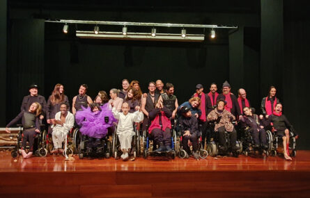 Perto de três dezenas de pessoas, em palco, alinhadas para a fotografia. Essencialmente são atores e atrizes da Companhia Era uma vez Teatro da APPC. Aparecem, igualmente, outros elementos da equipa técnica e do grupo musical que apoiou a apresentação. Ao fundo a imagem alguns holofotes.