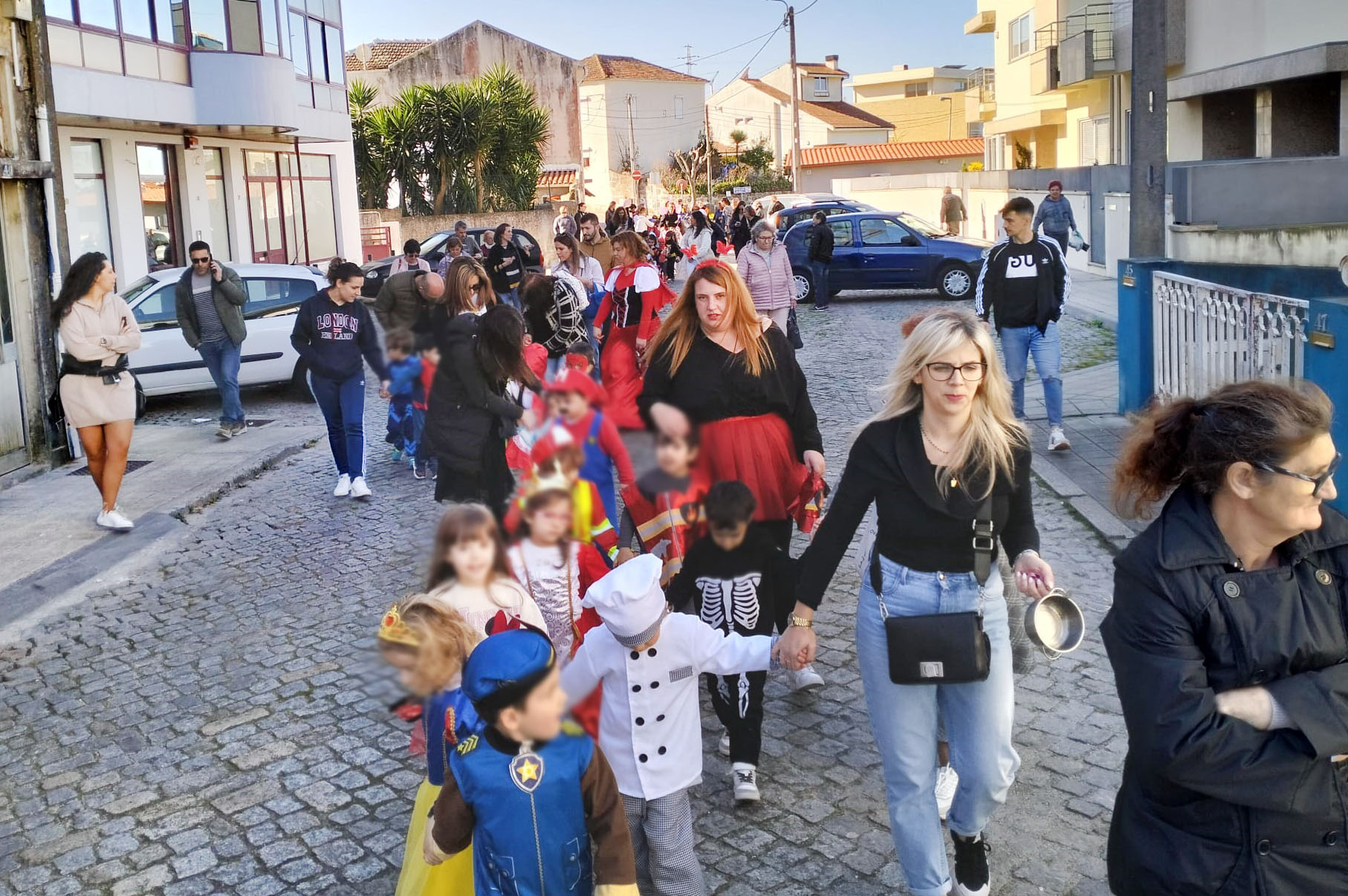 Fotografia de interior com pessoas sentadas (algumas em cadeira de rodas) durante o convívio de Carnaval.