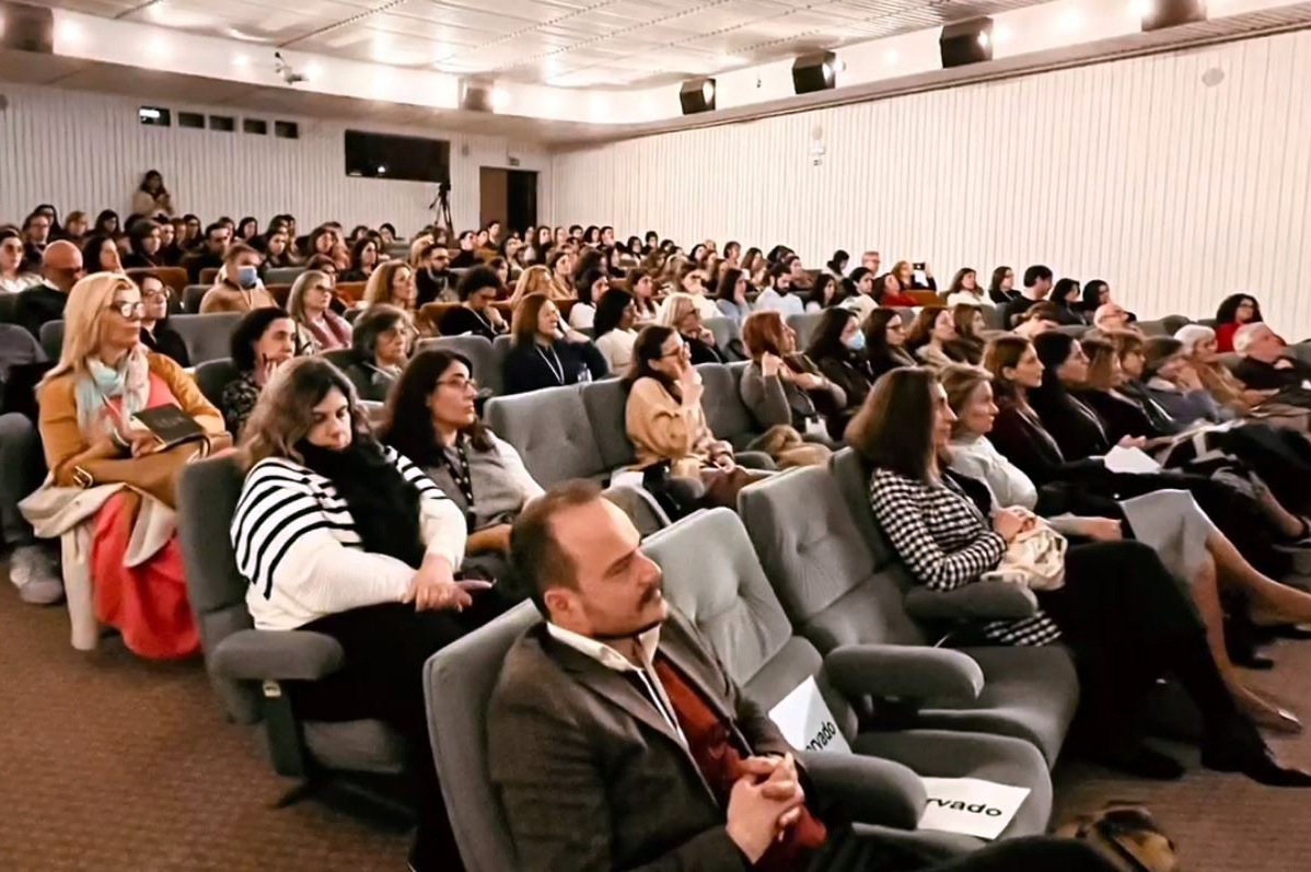 Aspeto da sala, com inúmeras pessoas sentadas no público.