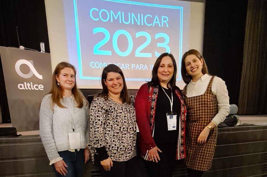 Foto de conjunto, com quatro pessoas, e fundo projetado da iniciativa.