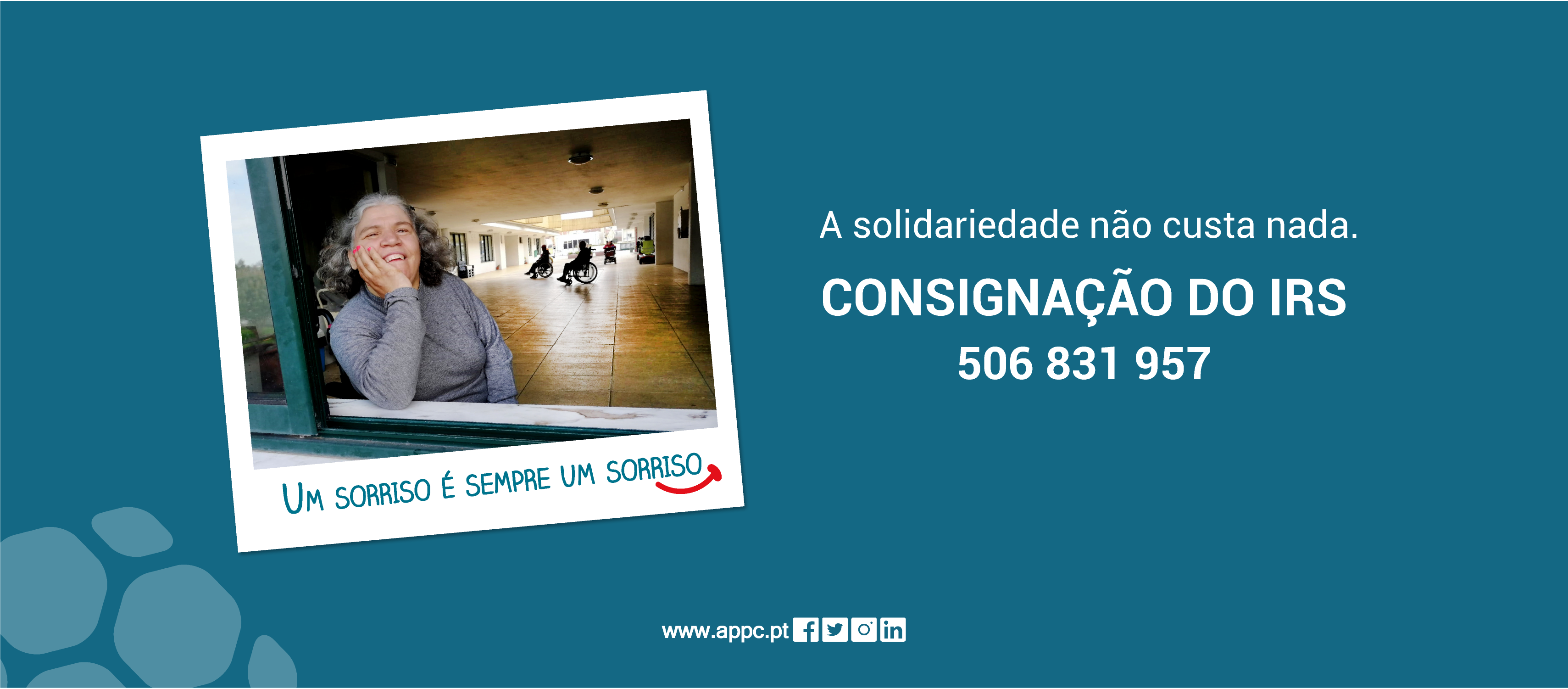 Imagem com fundo azul e com fotografia estilo Polaroid com senhora à janela a sorrir, sendo a imagem acompanhada da frase “Um sorriso é sempre um sorriso” e um ícone de sorriso a vermelho. A branco o texto “A solidariedade não custa nada” e “Consignação do IRS 506 831 957”. Abaixo, ainda, ícones com sítio institucional e redes sociais da APPC.