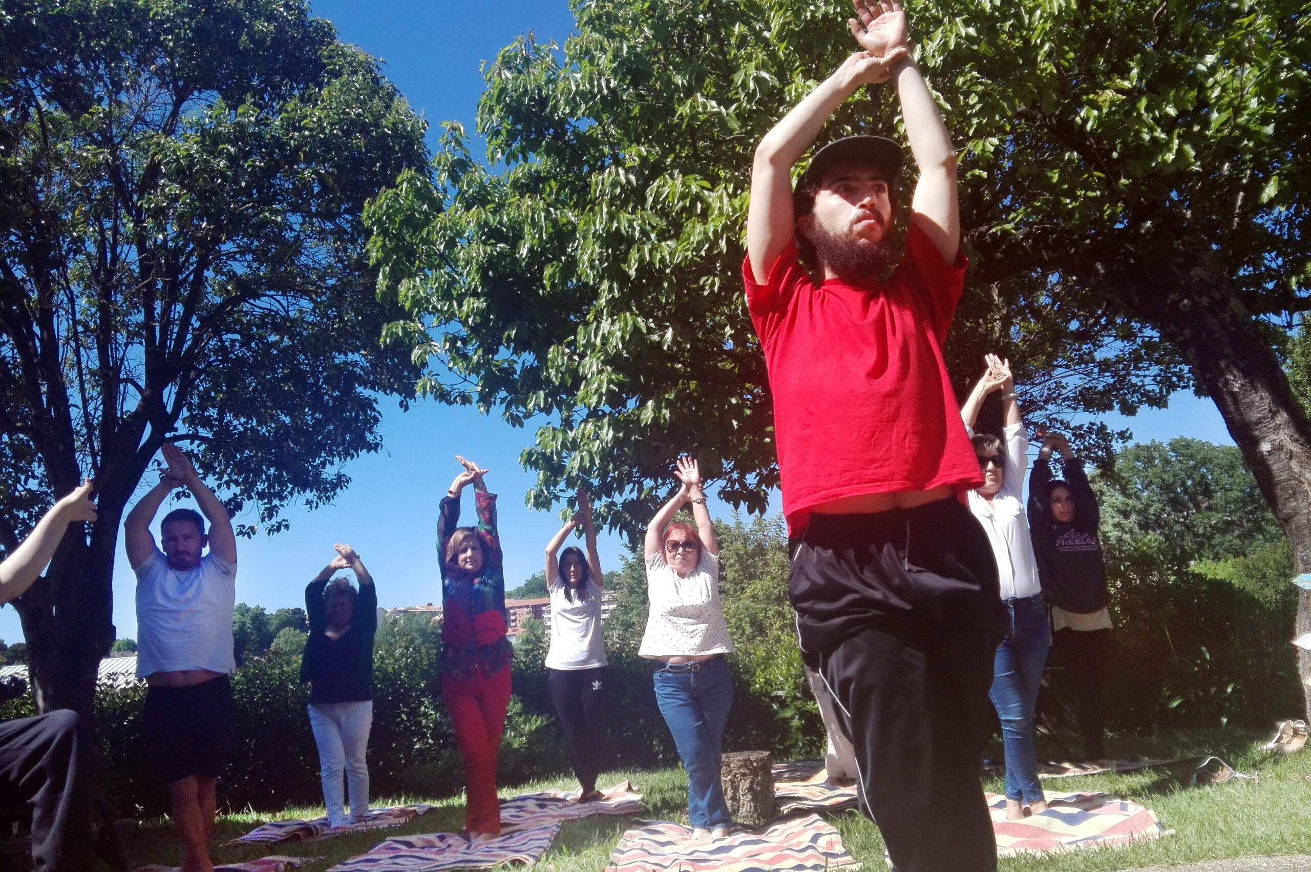 Grupo de pessoas em atividade de exterior, em jardim.