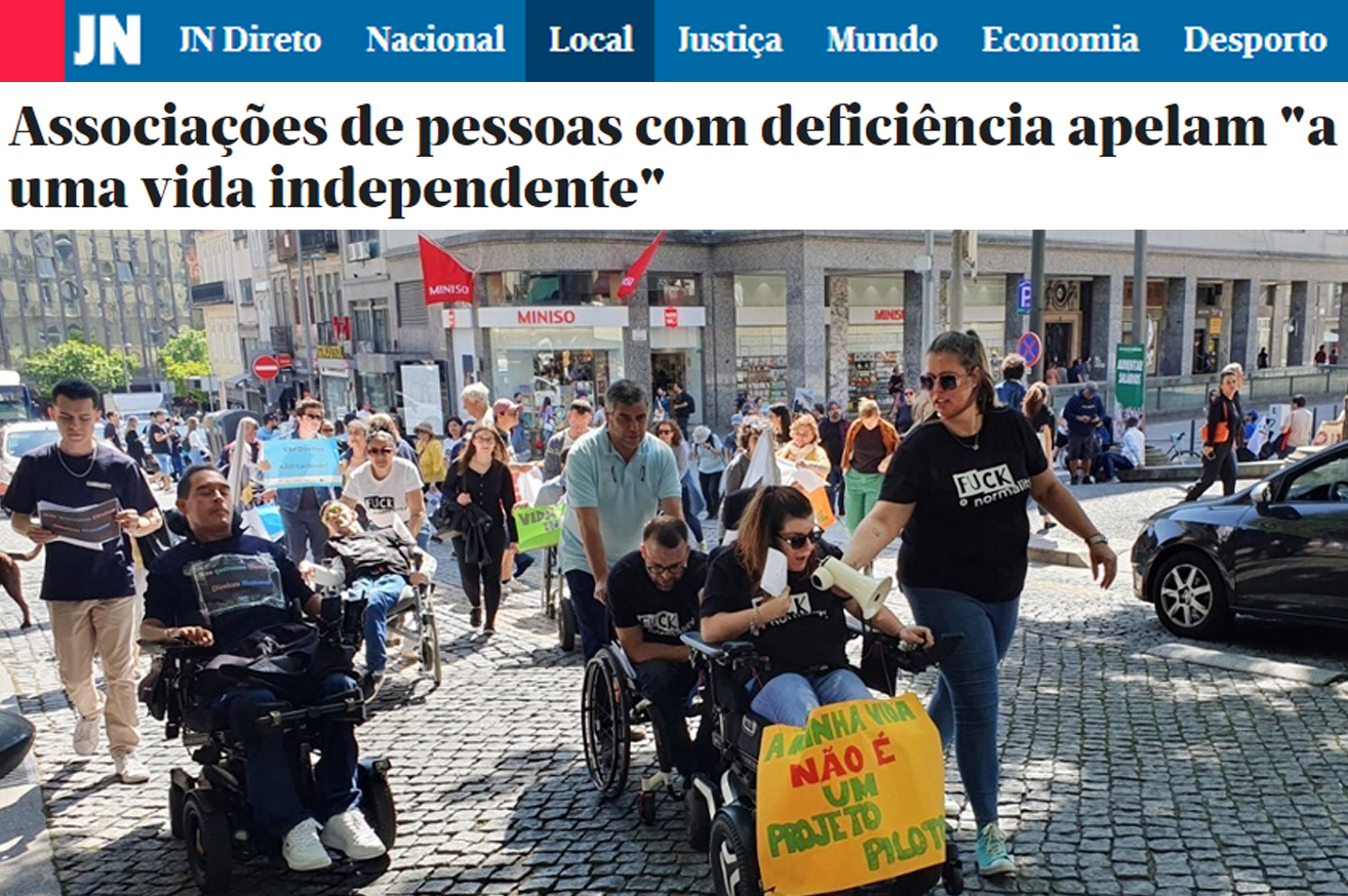 Cópia parcial de página do site do Jornal de Notícias (link na publicação). Título: Associações de pessoas com deficiência apelam a uma vida independente. Mais abaixo, fotografia de várias pessoas em manifestação, na rua. À frente do grupo seguem três pessoas em cadeiras de rodas. Uma delas usa um megafone e leva pendurado, na cadeira, um cartaz que diz: A minha vida não é um projeto piloto.