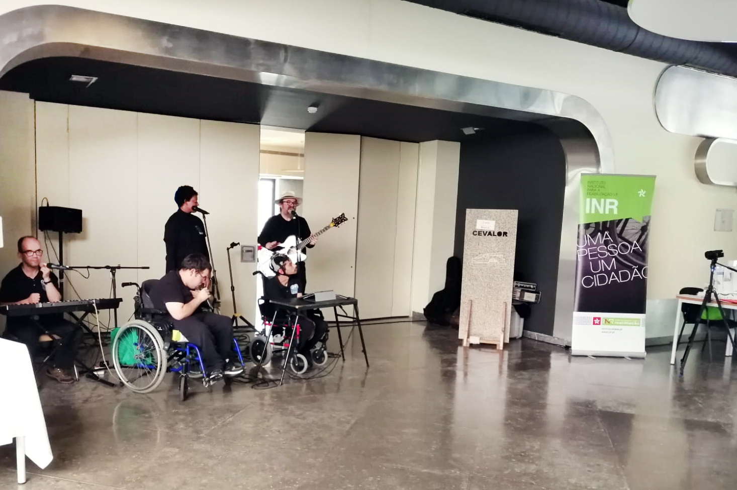 Fotografia da banda appSound em palco improvisado junto da entrada de um auditório. Na imagem estão cinco elementos da banda.