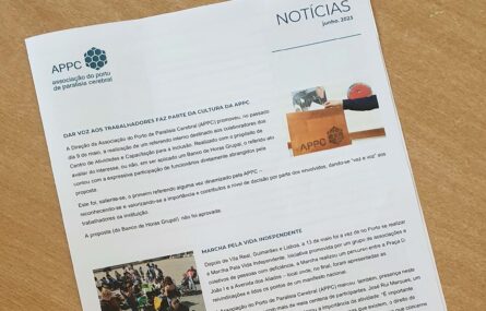 Fotografia da newsletter pousada em cima de uma mesa. Vê-se a primeira página e as duas notícias em destaque.