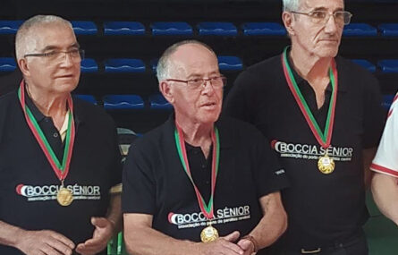 Fotografia de três dos elementos da Equipa de Boccia Sénior da “Villa Urbana” de Valbom, da APPC. São três pessoas, do sexo masculino, com medalhas ao peito e a usarem camisola azul (escuro) com a inscrição Boccia Sénior Associação do Porto de Paralisia Cerebral.