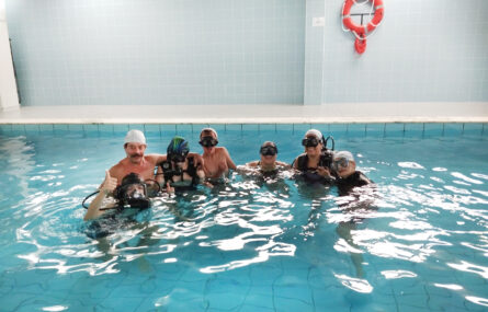 Grupo de sete pessoas na piscina da Villa Urbana de Valbom. Algumas estão a usar equipamento para mergulho.