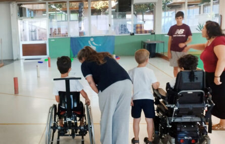 Seis pessoas em campo de Boccia em espaço interior.