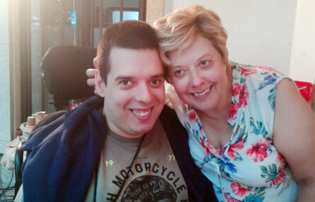 Duas pessoas sorriem para a foto.