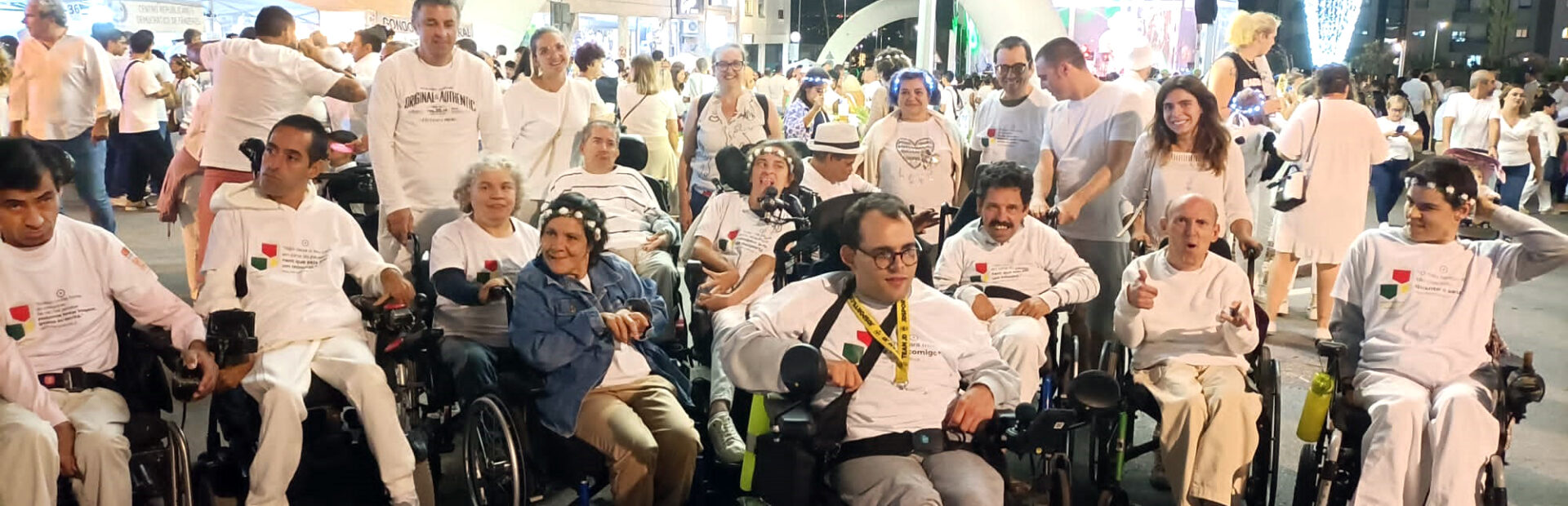 Grupo de elementos da Villa Urbana de Valbom em fotografia conjunta, na rua, no meio da atividade da Noite Branca de Gondomar. São cerca de duas dezenas de pessoas sendo que, na imagem, ainda são visíveis mais algumas dezenas (ou centenas) de participantes no evento. Ao fundo ainda se vê um dos palcos.