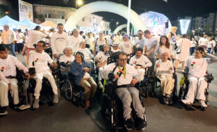 Grupo de elementos da Villa Urbana de Valbom em fotografia conjunta, na rua, no meio da atividade da Noite Branca de Gondomar. São cerca de duas dezenas de pessoas sendo que, na imagem, ainda são visíveis mais algumas dezenas (ou centenas) de participantes no evento. Ao fundo ainda se vê um dos palcos.