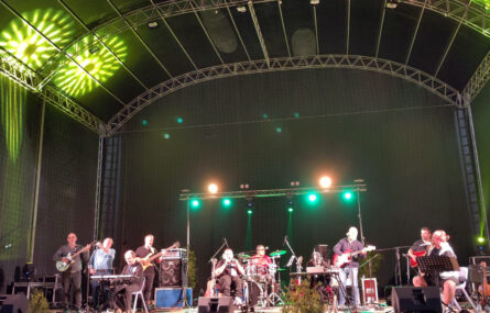 Fotografia da atuação conjunta da banda appSound e do conjunto Curt&Grosso Ensemble. Em palco estão dez pessoas. A iluminação do palco é, na altura, de tons esverdeados.