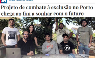 Cópia parcial de notícia publicada no sítio do Jornal de Notícias. Em cima barra com logótipo do JN. Depois título da notícia “Projeto de combate à exclusão no Porto chega ao fim a sonhar com o futuro” e logo abaixo fotografia de sete pessoas (de pé e sentadas) junto da uma mesa de pedra de um jardim. Em cima da mesa está pousado um computador portátil. Atrás das pessoas uma árvore e alguns arbustos.