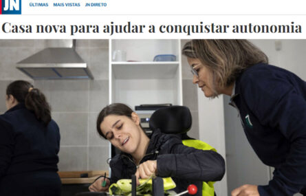 Captura de ecrã de página do sítio do “Jornal de Notícias”. Notícia com o título “Casa nova para ajudar a conquistar autonomia” acompanhada de fotografia na qual aparecem três pessoas – ao centro, sentada em cadeira de rodas, uma pessoa corta parcialmente uma curgete; à direita outra pessoa olha atentamente; ao fundo da imagem algum equipamento de cozinha e uma outra pessoa, mas de costas.