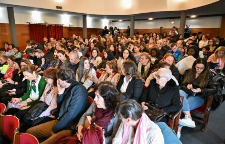 Perspetiva diagonal de várias dezenas de pessoas sentadas na sala de espetáculos da Escola Dramática e Musical Valboense. Ao fundo, em pé, estão ainda mais algumas pessoas.