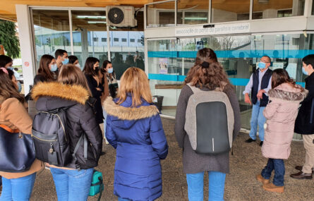 Pessoas a conversar na zona de entrada do Centro de Reabilitação da APPC. Vê-se a zona de acesso ao Centro. Todas as pessoas na imagem usam máscara de proteção individual.