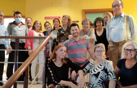 Grupo de 16 pessoas junto de escadas. Algumas estãos entadas (ou ajoelhadas) nos primeiros degraus. As outras, em pé, sorriem para a fotografia.
