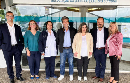 Grupo de sete pessoas junto da entrada principal do Centro de Reabilitação da APPC.