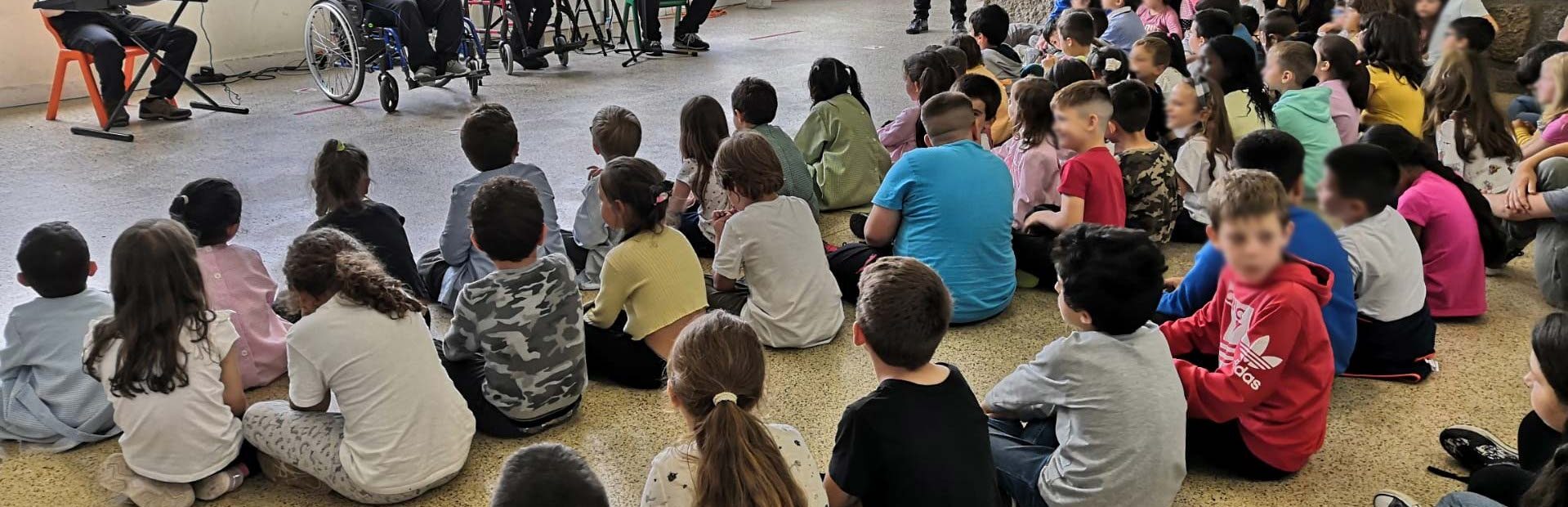 Atuação da banda appSound em espaço interior. Além dos quatro elementos da banda surgem cerca de três dezenas de alunos (sentados no chão). Os rostos visíveis das crianças foram desfocados.
