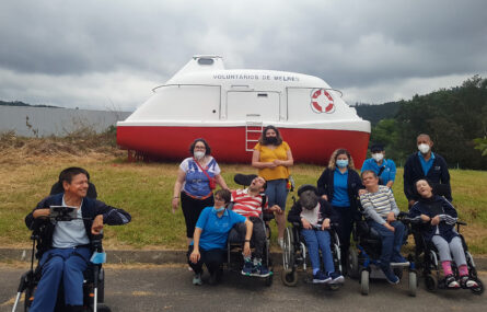 Grupo de 11 pessoas em espaço exterior. Atrás das pessoas, em zona relvada, está o que aparenta ser um pequeno barco (de apoio ou de socorro) que apresenta a inscrição “Voluntários de Melres”. Árvores ao fundo.