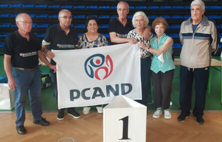 Grupo de sete pessoas. Algumas seguram uma bandeira com a inscrição PCAND.