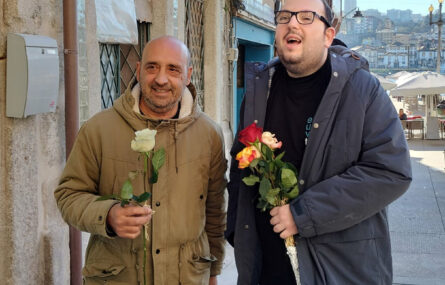 Duas pessoas, sorridentes, a segurarem rosas nas mãos.