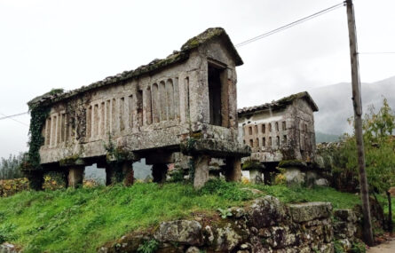 Fotografia de dois espigueiros, em pedra. Um deles (em primeiro plano) está parcialmente destruído.