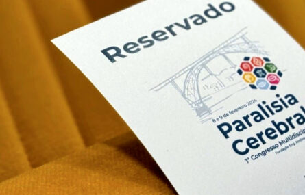 Grande plano de pedaço de papel colocado em cadeira. O referido tem impressa a palavra “Reservado” e a imagem gráfica do congresso de paralisia cerebral.