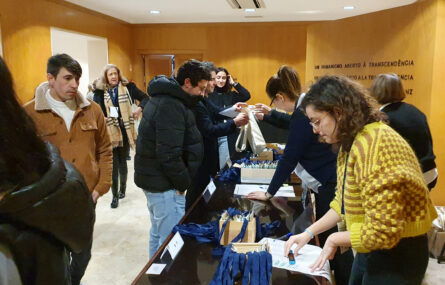 Várias pessoas junto de mesa repleta de material. Aparentam estar a proceder à inscrição no congresso.