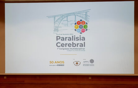 Fotografia de projeção em tela gigante com a imagem gráfica do primeiro congresso multidisciplinar de paralisia cerebral (e referência aos 50 anos da APPC).