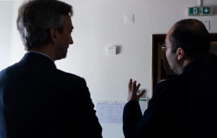 De costas estão duas pessoas a conversar.