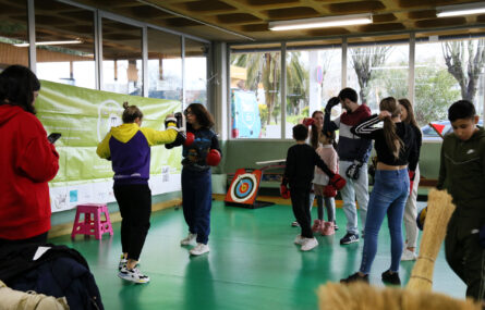 Várias crianças e jovens praticam kickboxing em espaço interior.