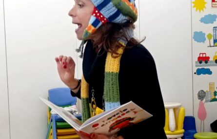 Uma pessoa adulta segura um livro aberto enquanto aparenta estar a ler.