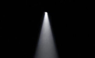 Imagem de um foco de luz a iluminar o que aparenta ser um palco.