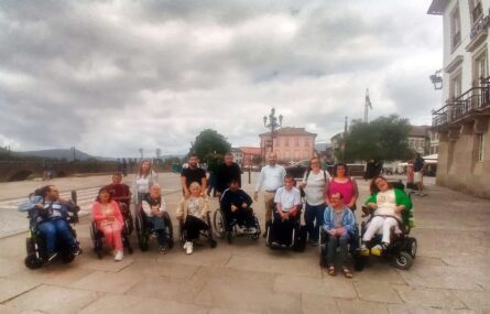 Fotografia de grupo com 15 pessoas (em zona exterior junto a alguns edifícios).