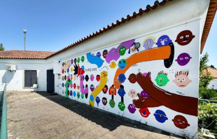 Mural colorido com inúmeras imagens pintado em parede exterior.