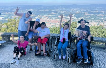 Seis pessoas num local que aparenta ser um miradouro. Ao fundo, na paisagem, vê-se edificado, zonas verdes e imensos montes.