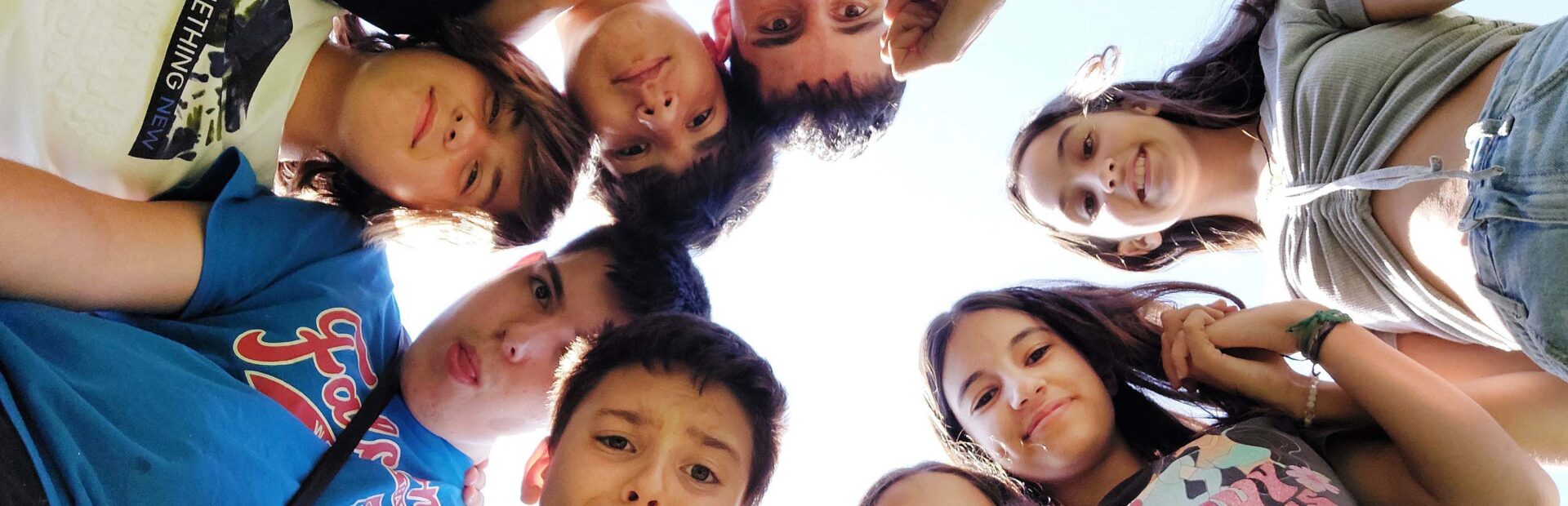 Fotografia de nove crianças e jovens que formam um círculo com os respetivos rostos.