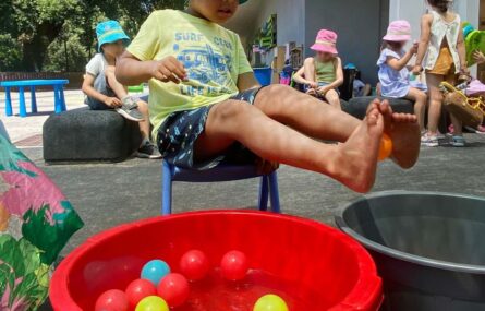 crianças em espaço exterior e uma delas brinca com água