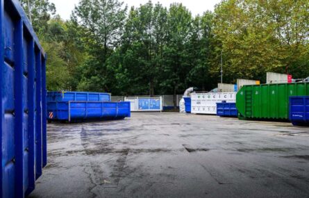 Fotografia de espaço exterior com vários contentores. Árvores ao fundo da imagem.