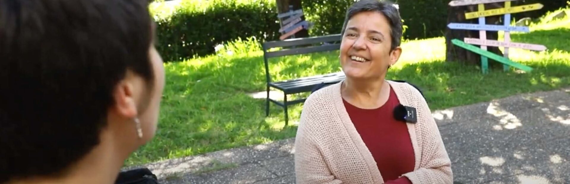 Fotograma de vídeo onde podem ver-se duas pessoas a conversar., num espaço que parece ser um jardim exterior.