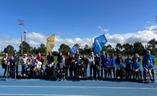 Mais de três dezenas de pessoas alinhadas, lado a lado, em pista exterior do que aparenta ser um complexo de atletismo. Ao fundo imensas árvores. Atrás do grupo estão duas bandeiras (estandartes) com a indicação escrita Seixalíada.