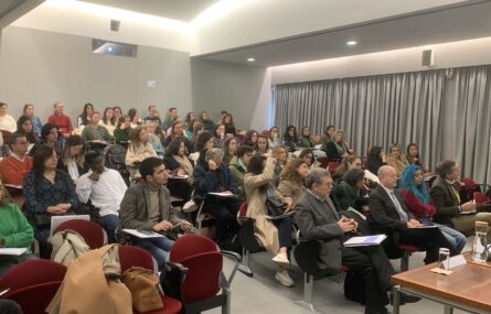 Imagem de auditório interior com várias dezenas de pessoas sentadas na zona da plateia.