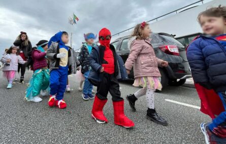 Grupo de crianças mascaradas a descer uma rua. Os rostos identificáveis das crianças foram digitalmente desfocados.