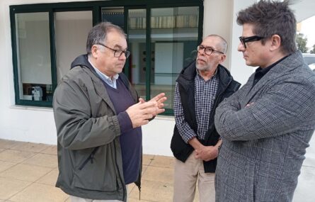 Três pessoas, em espaço exterior, durante uma conversa informal.