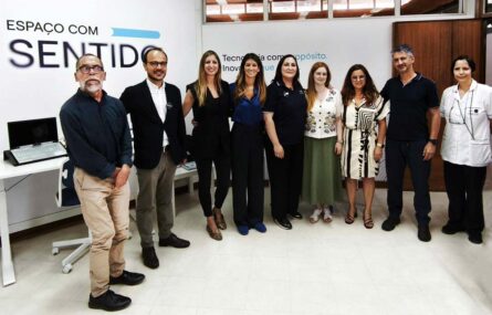 Grupo de nove pessoas, lado a lado, alinhadas para registo fotográfico. Fotografia em espaço interior.