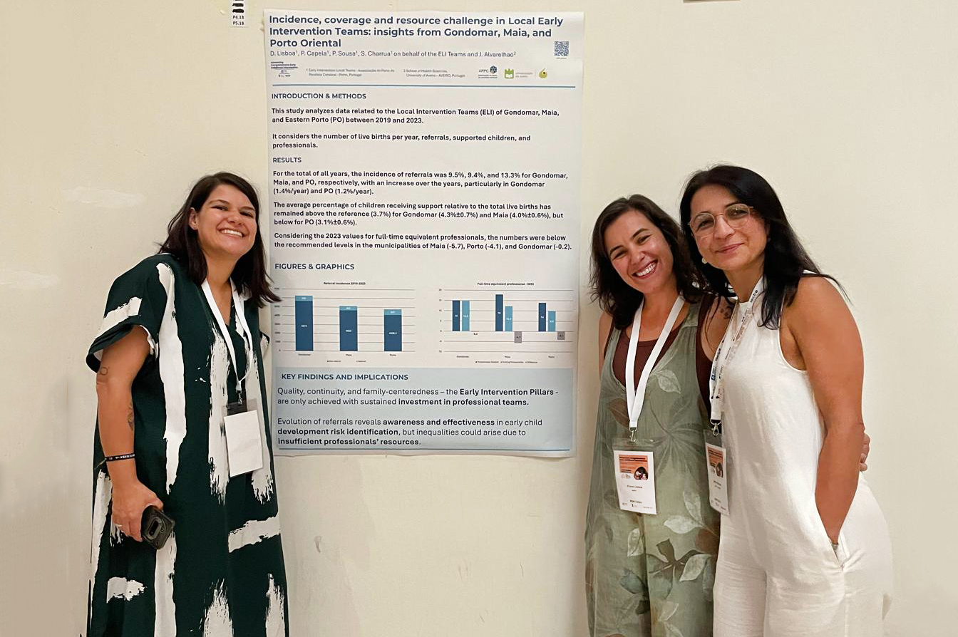 Três pessoas, sorridentes, junto de um poster com informações (afixado numa parede).